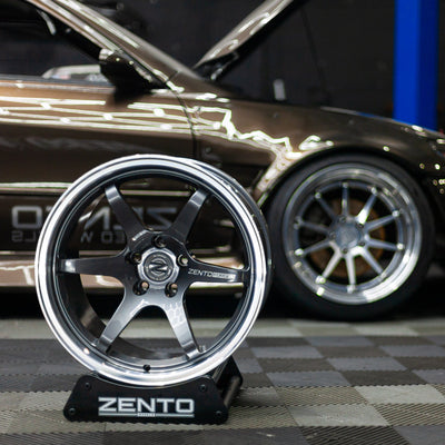 Zento MS4 Monoblock forged aluminium drift and motorsport wheel in workshop, shown with concave and dual colour on alloy wheel stand in front of drift car with Zento MS1