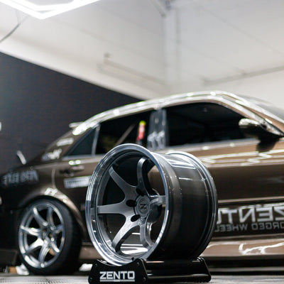 Zento MS4 Monoblock forged aluminium drift and motorsport wheel in workshop, shown with concave and dual colour on alloy wheel stand in front of drift car with Zento MS1